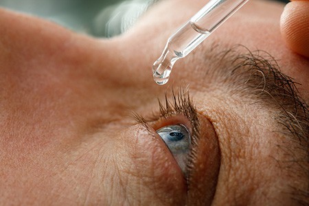 Close-up of a person receiving eye drops, highlighting eye care treatment for common eye problems.