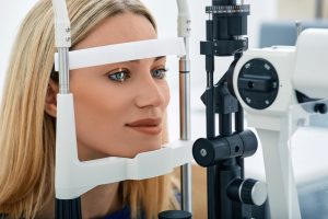 Woman undergoing an eye exam using a slit lamp, emphasizing the importance of regular eye check-ups for vision health.